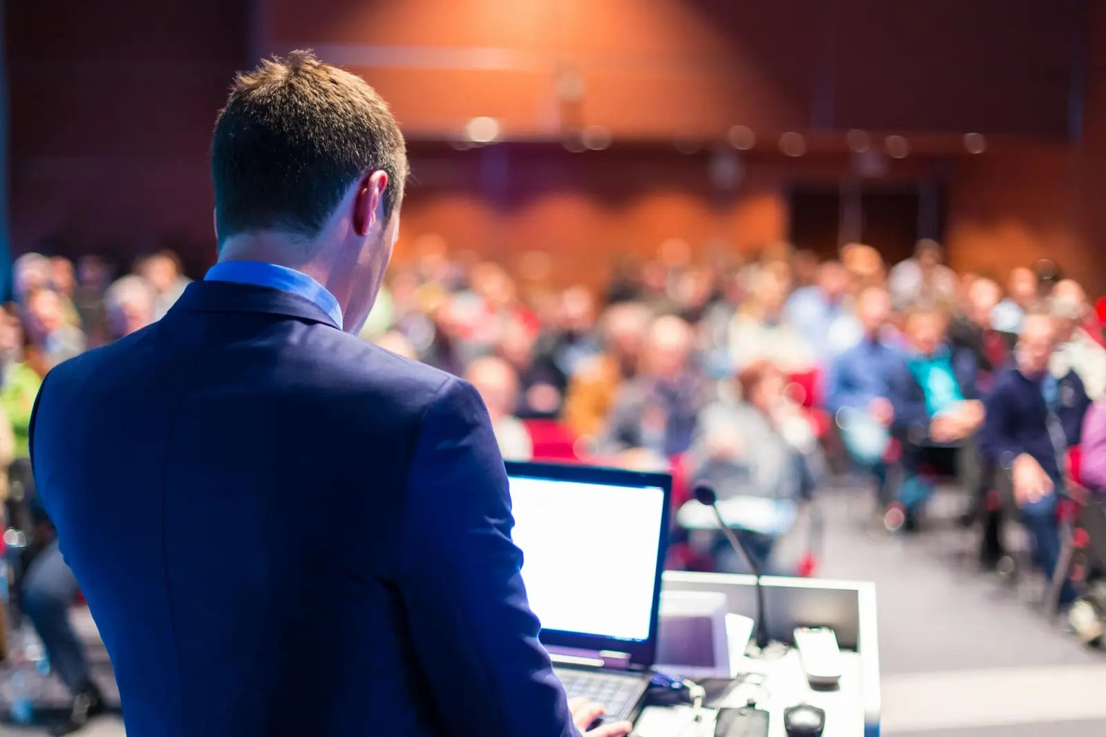 A speaker addressing a full auditorium